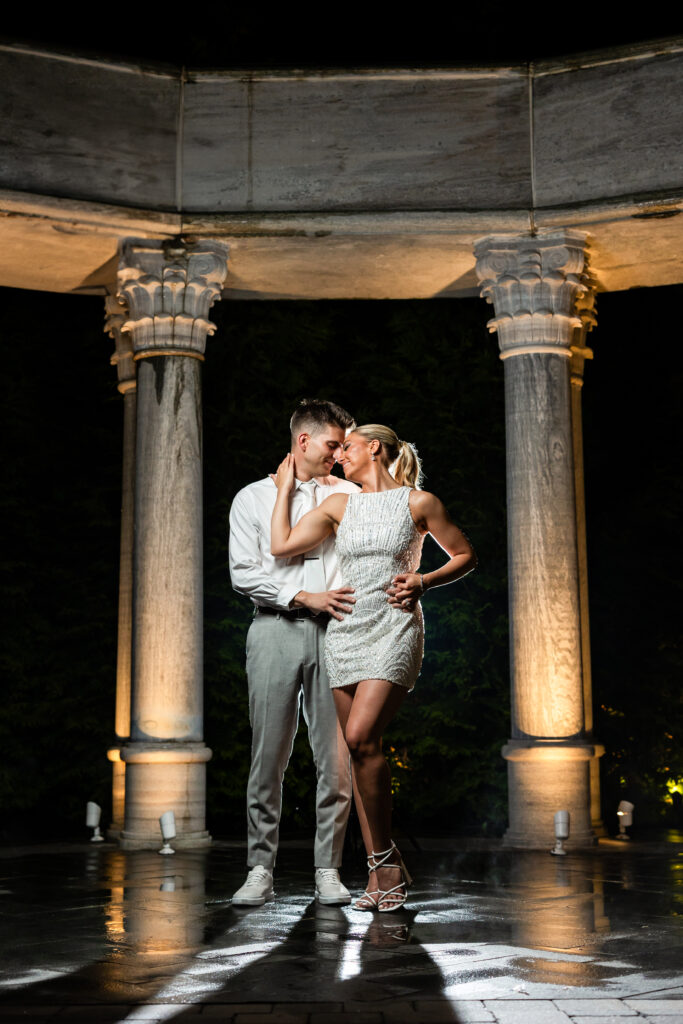 A bride and groom captured by New Jersey Wedding Photographer Jarot Bocanegra share a romantic kiss in front of a gazebo at night.