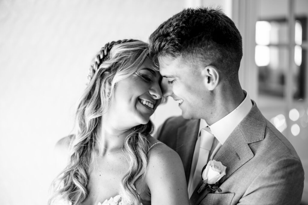 A black and white photo of a bride and groom hugging, captured by New Jersey Wedding Photographer.