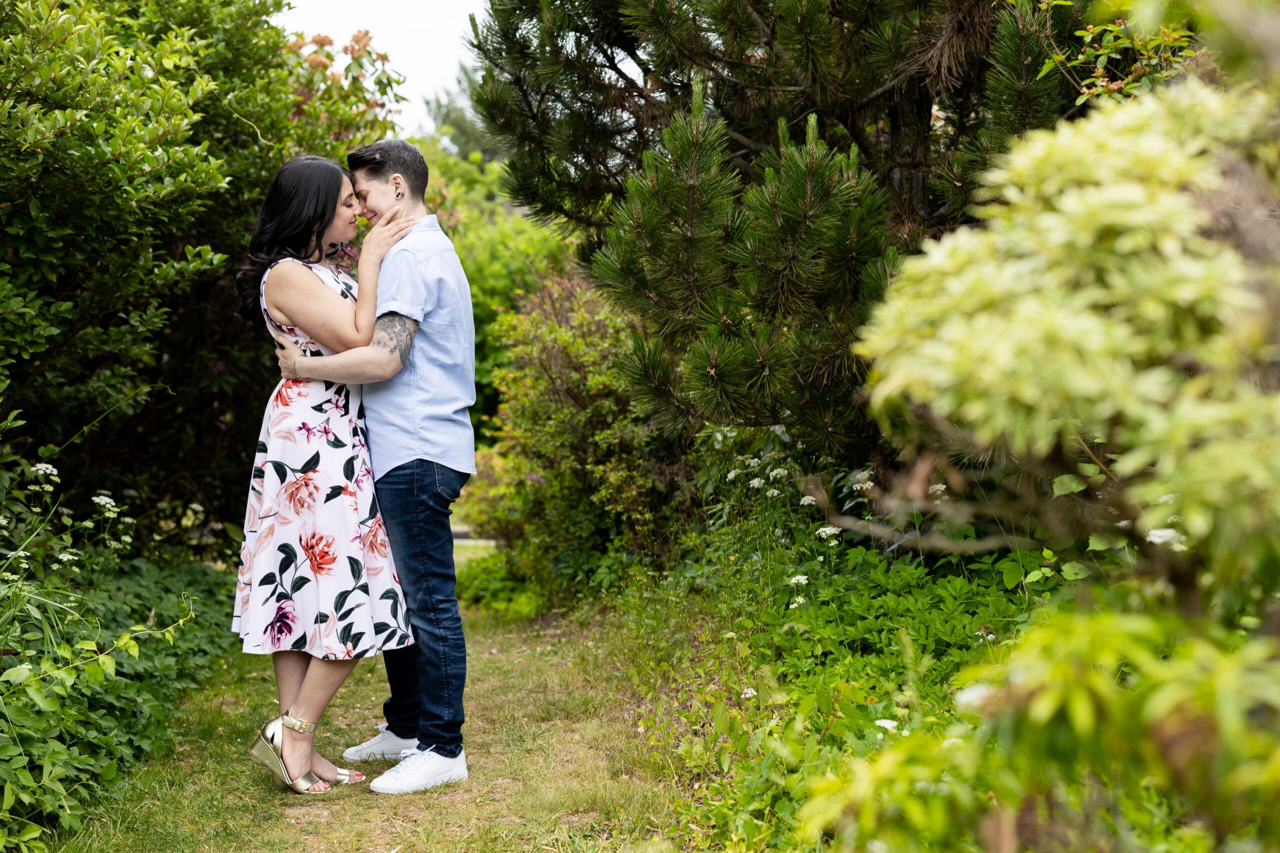 An engaged couple captured by New Jersey Wedding Photographer Jarot Bocanegra, kissing in a garden.