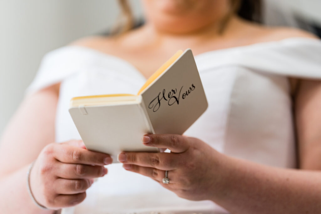 A bride in a wedding dress holding a book, captured by New Jersey Wedding Photographer Jarot Bocanegra.