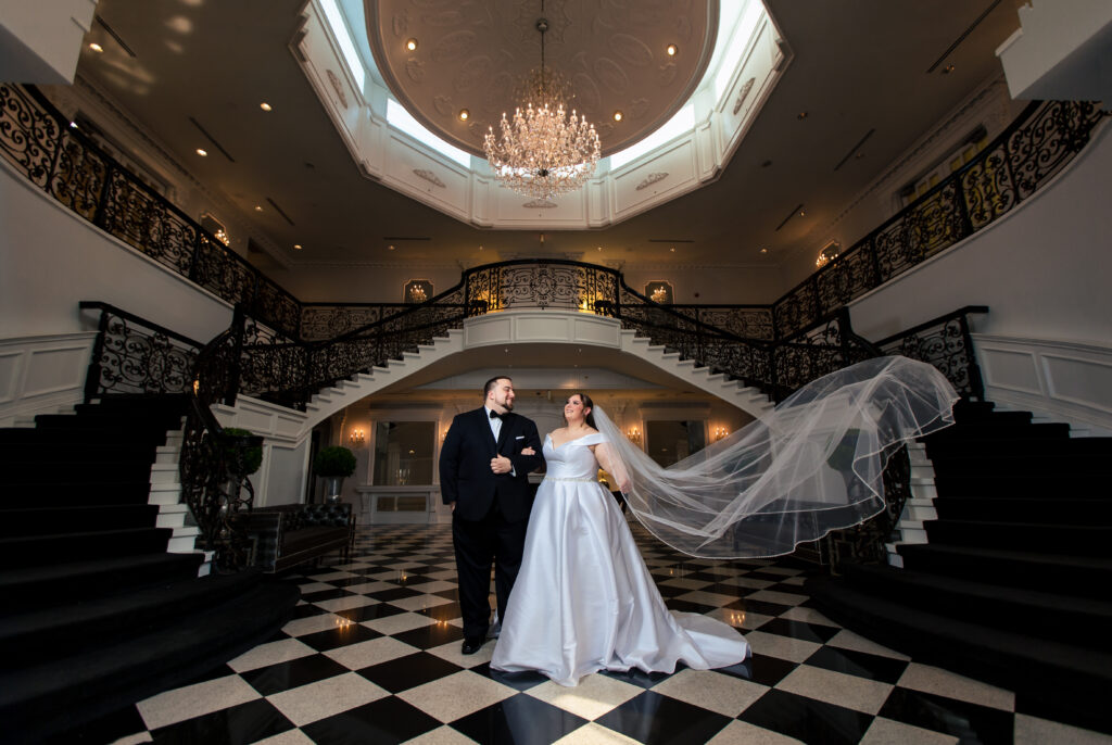 A bride and groom standing in front of a checkered staircase, captured by New Jersey Wedding Photographer Jarot Bocanegra.