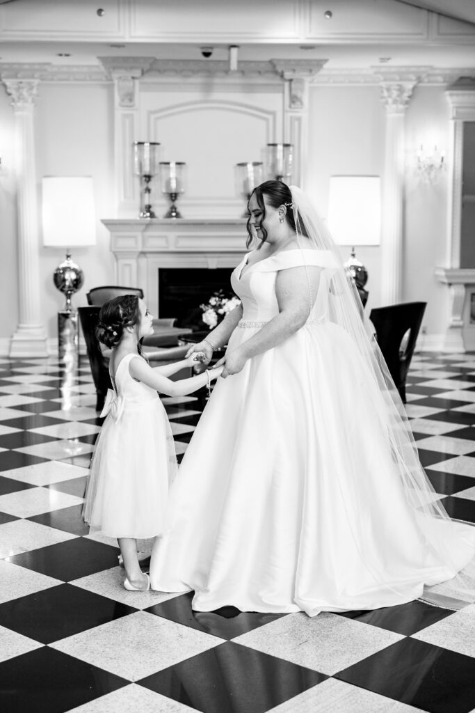 A bride and her flower girl in a black and white photo, captured by New Jersey Wedding Photographer Jarot Bocanegra.