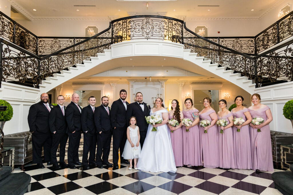 A wedding party standing in front of a staircase, captured by New Jersey Wedding Photographer Jarot Bocanegra.