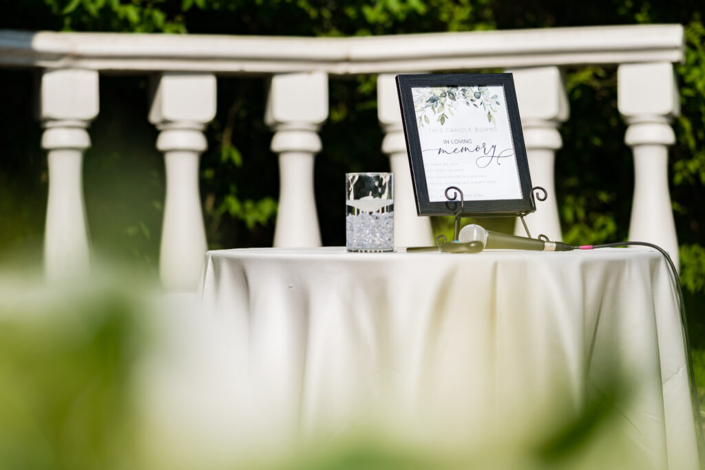 A table with a sign on it and a glass of water, captured by New Jersey Wedding Photographer Jarot Bocanegra.