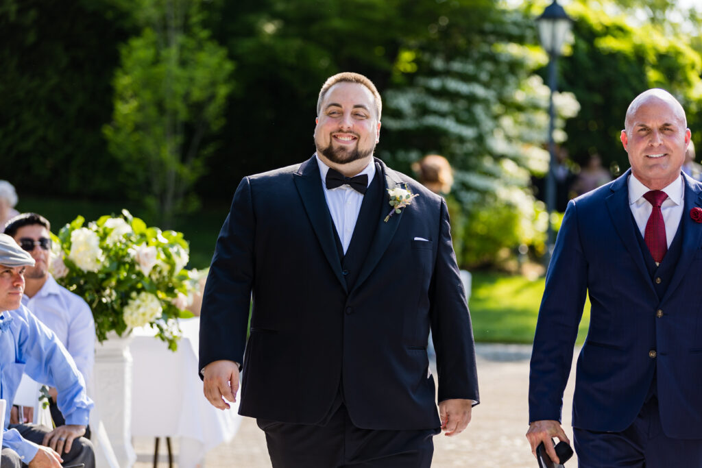 Two men in tuxedos walking down the aisle, captured by New Jersey wedding photographer.