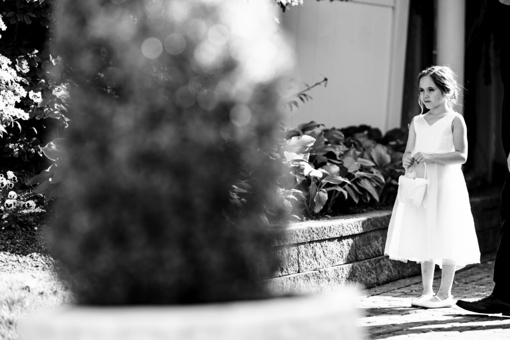 Black and white photo of a little girl walking down a path, captured by New Jersey Wedding Photographer Jarot Bocanegra.