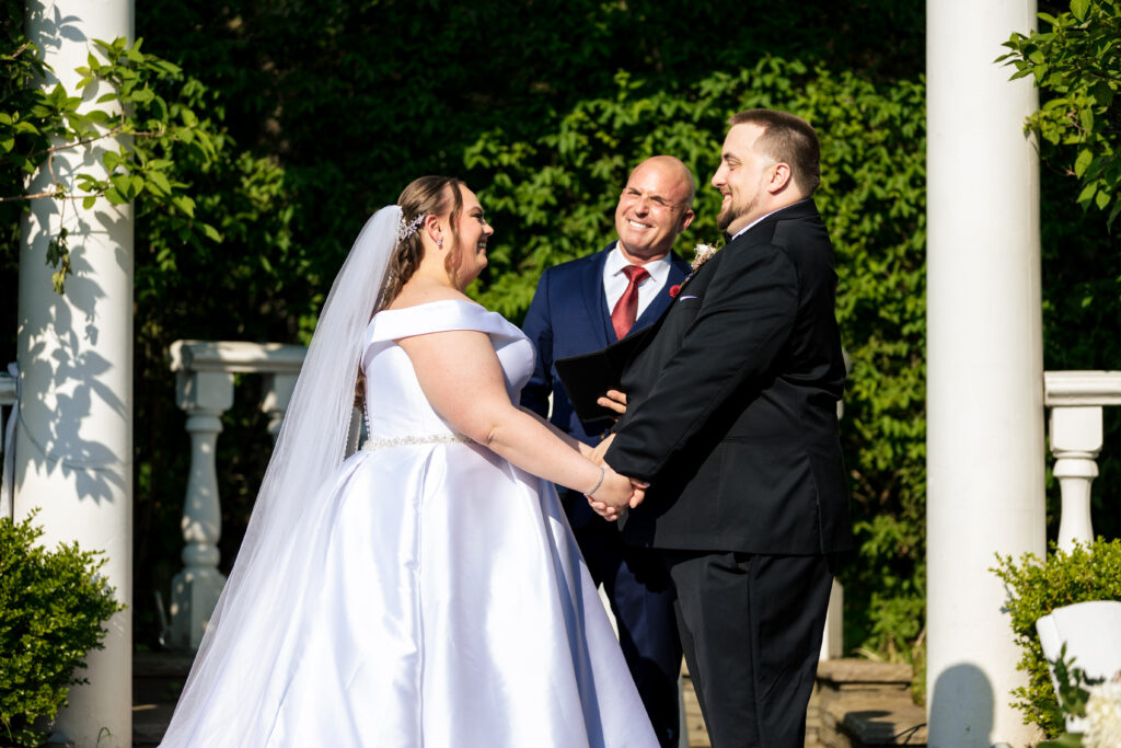A bride and groom exchange vows in front of a gazebo, captured by New Jersey Wedding Photographer Jarot Bocanegra.