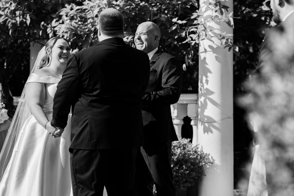 A bride and groom captured by New Jersey Wedding Photographer Jarot Bocanegra, smiling at each other during their wedding ceremony.