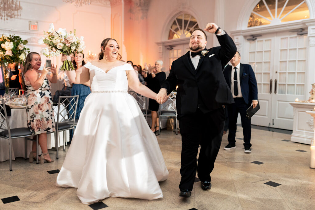 A bride and groom, captured by New Jersey Wedding Photographer Jarot Bocanegra, walking down the aisle at their wedding reception.