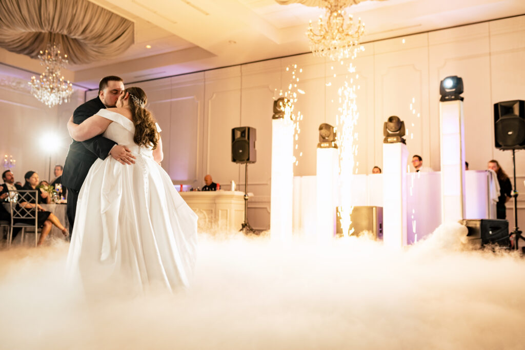 A captivating firework display enhances the intimate dance shared by a beautiful bride and groom, skillfully captured by New Jersey Wedding Photographer Jarot Bocanegra.