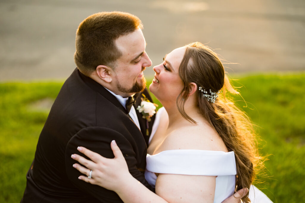 A bride and groom kissing in the grass at sunset, captured by New Jersey Wedding Photographer Jarot Bocanegra.