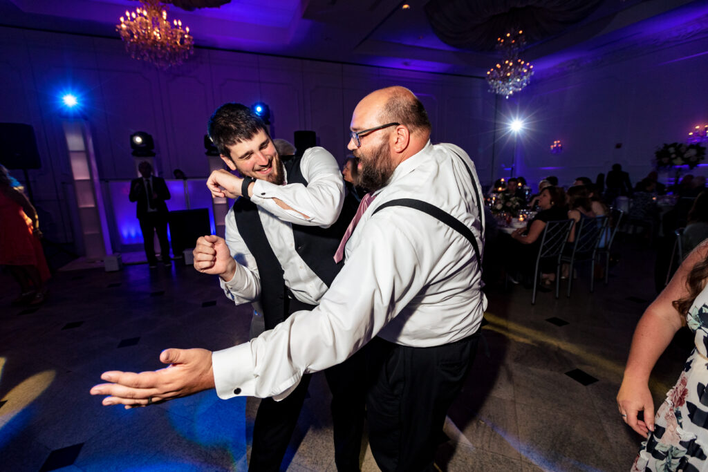 Two men dancing at a wedding reception, captured by New Jersey Wedding Photographer Jarot Bocanegra.