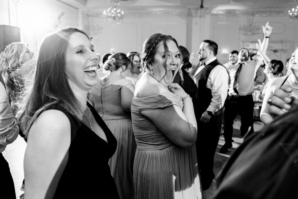 A captivating black and white photo of a group of people dancing at a wedding, expertly captured by New Jersey Wedding Photographer Jarot Bocanegra.