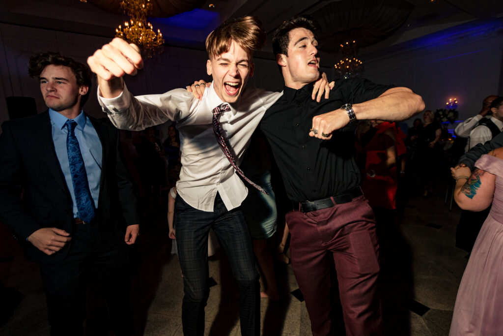 Two young men captured by New Jersey Wedding Photographer Jarot Bocanegra dancing on the dance floor at a party.
