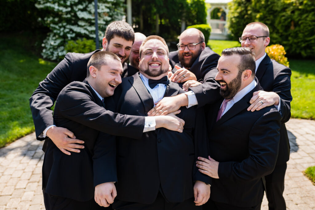 A group of groomsmen hugging for a photo, captured by New Jersey Wedding Photographer Jarot Bocanegra.
