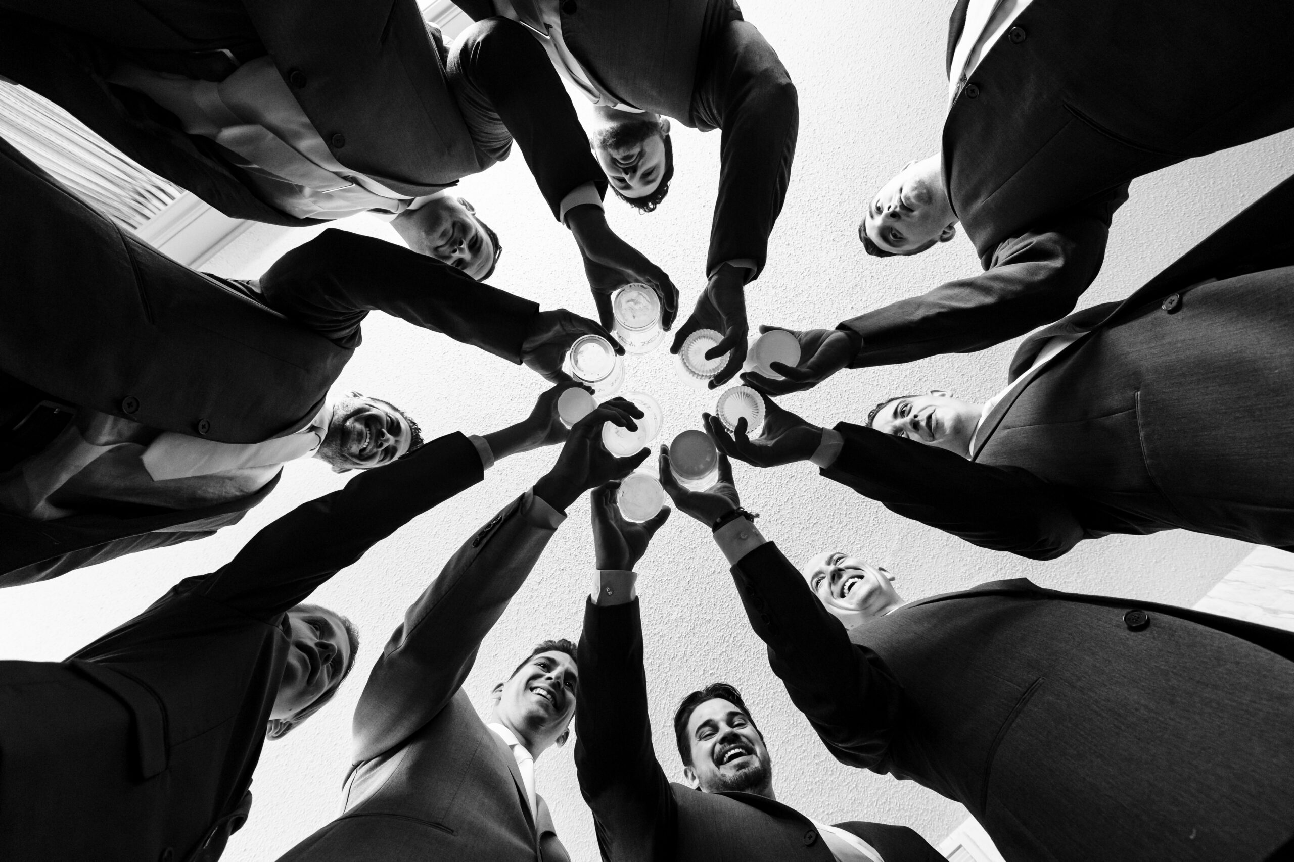 A group of business people holding hands in a circle, captured by New Jersey Wedding Photographer Jarot Bocanegra.