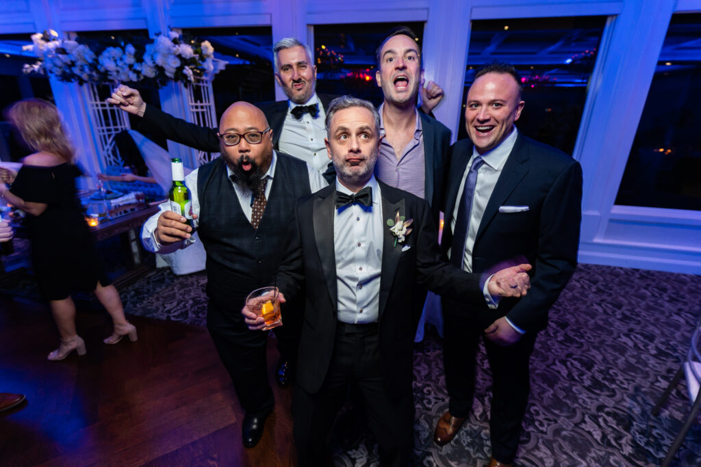 A group of men posing for a photo at a wedding reception, captured by New Jersey Wedding Photographer Jarot Bocanegra.