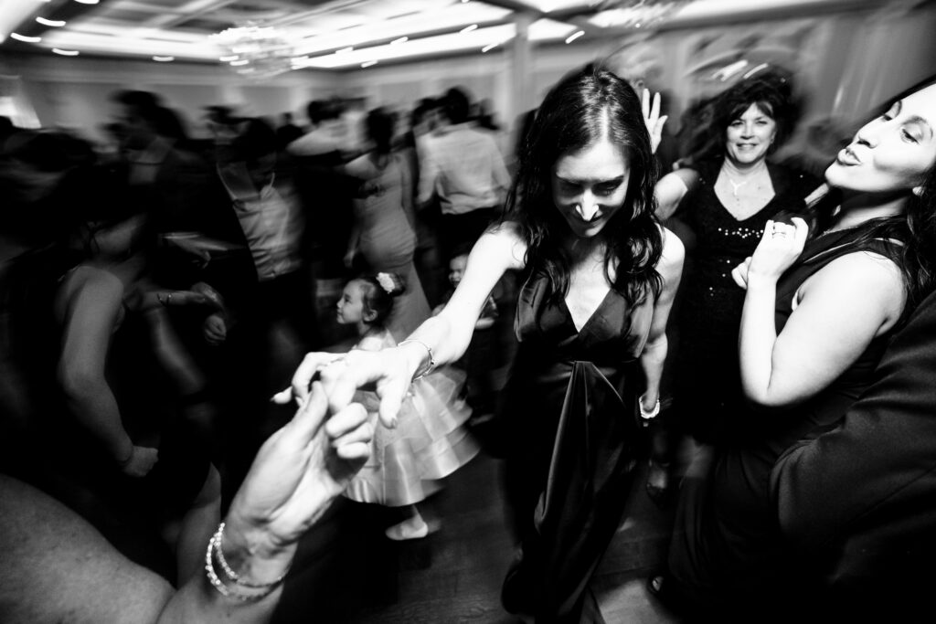 A black and white photo of people dancing at a wedding, captured by New Jersey Wedding Photographer Jarot Bocanegra.