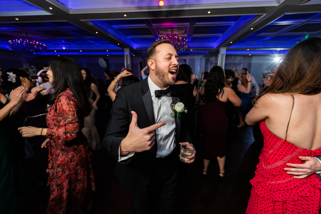 A man in a tuxedo dancing at a wedding reception, captured by New Jersey Wedding Photographer.
