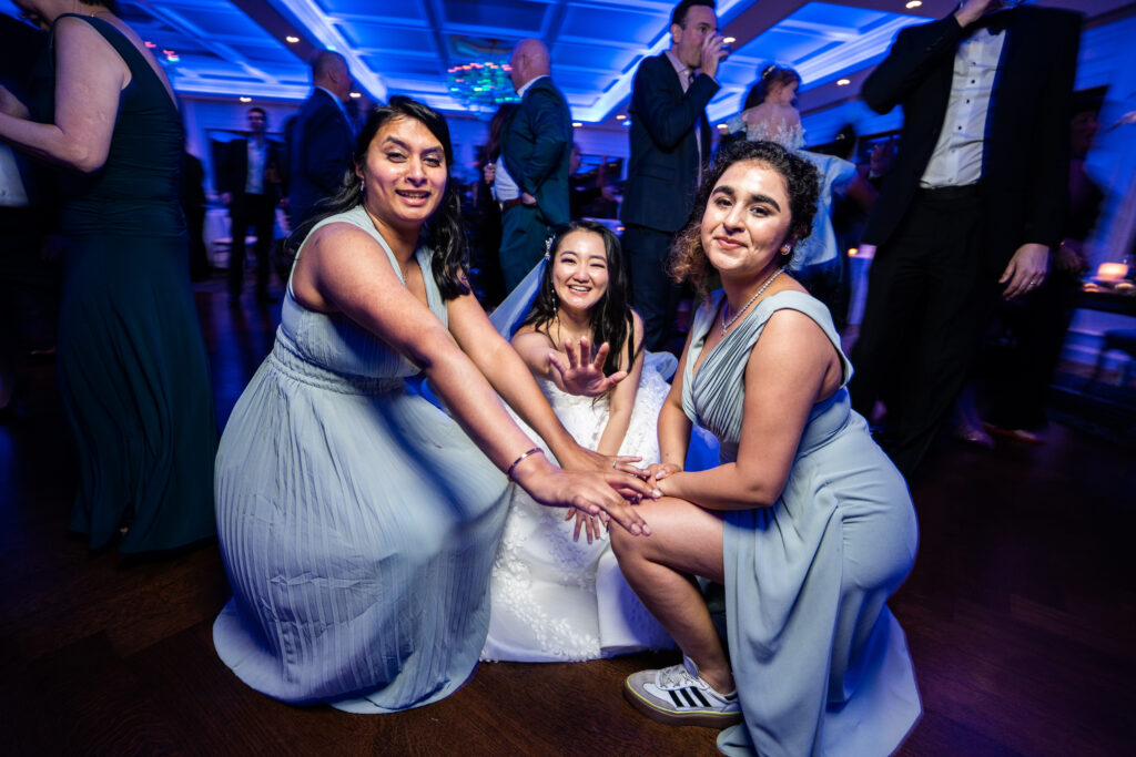 Three bridesmaids captured by New Jersey Wedding Photographer Jarot Bocanegra on the dance floor at a wedding.