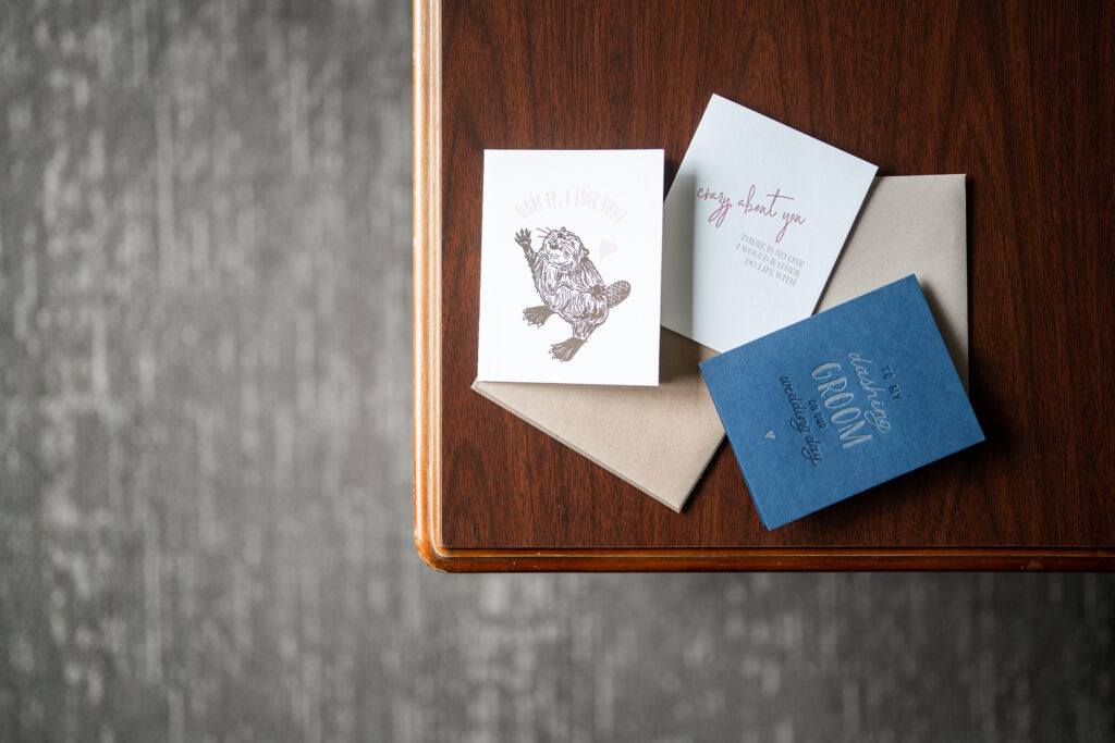 A stack of cards on a wooden table, captured by New Jersey Wedding Photographer Jarot Bocanegra.