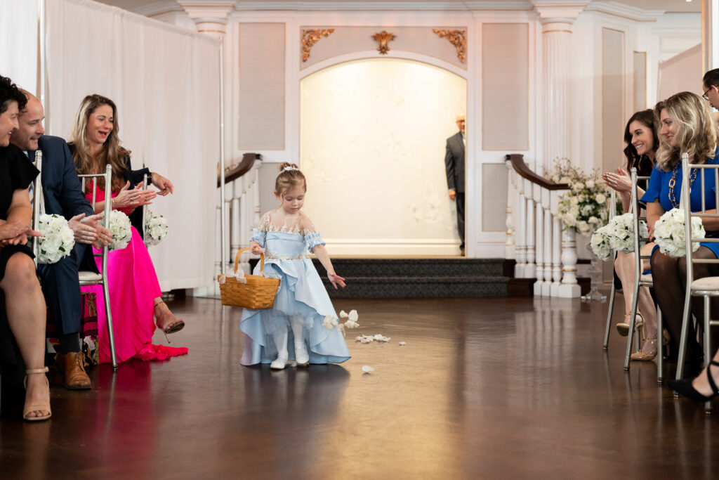 A little girl walking down the aisle at a wedding, captured by New Jersey Wedding Photographer Jarot Bocanegra.