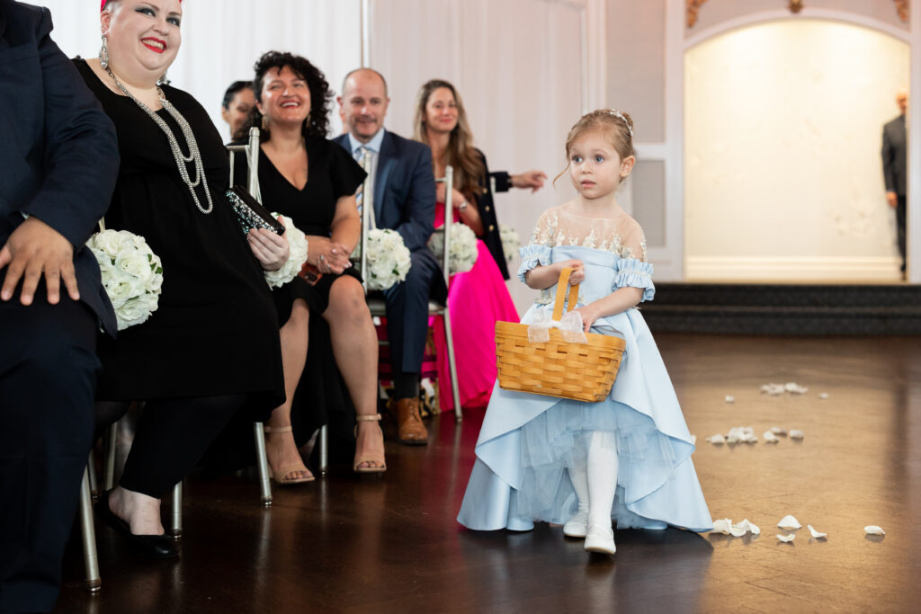 A little girl, captured by New Jersey Wedding Photographer Jarot Bocanegra, walking down the aisle at a wedding.
