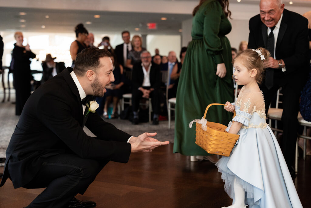 A little girl is standing next to a man at a wedding, captured by New Jersey Wedding Photographer Jarot Bocanegra.