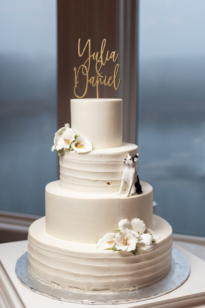 A white wedding cake with a cat on top, captured by New Jersey Wedding Photographer Jarot Bocanegra.
