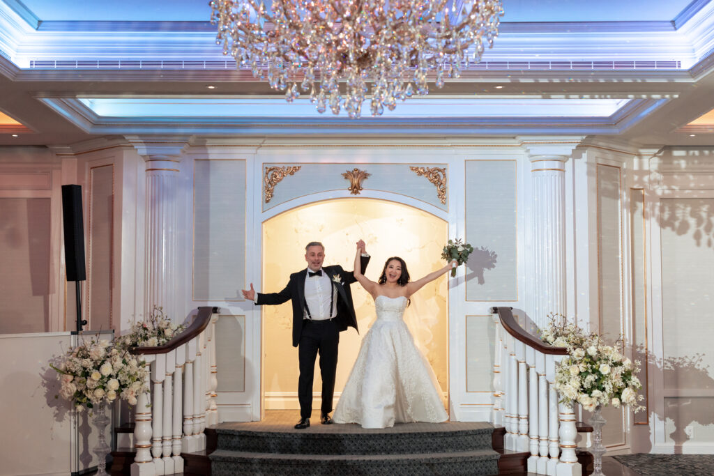 A bride and groom captured by New Jersey Wedding Photographer Jarot Bocanegra, standing in front of a chandelier.