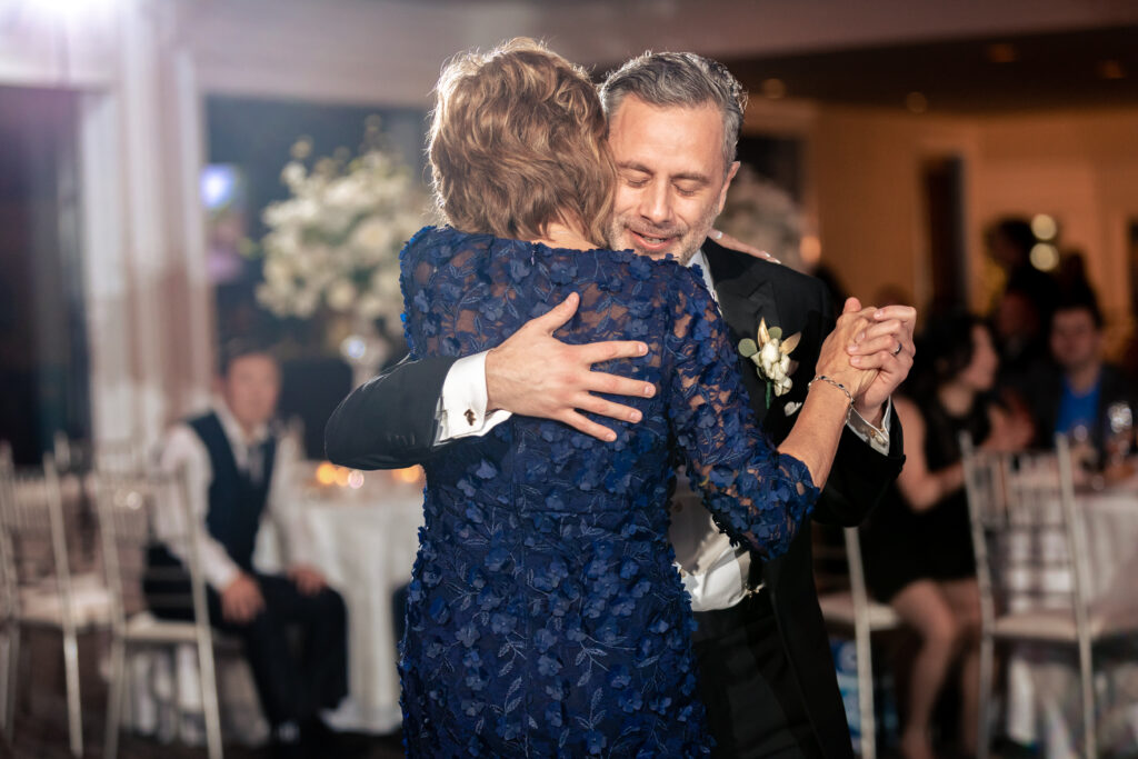 A man and woman hugging during their first dance at a wedding reception, captured by New Jersey Wedding Photographer Jarot Bocanegra.