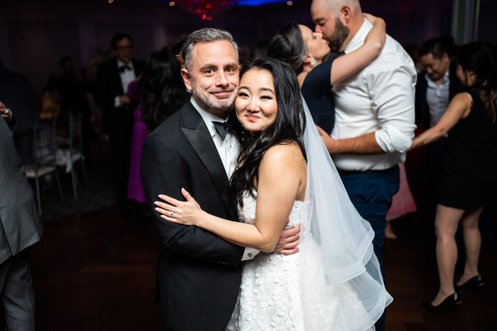 Captured by New Jersey Wedding Photographer Jarot Bocanegra, a bride and groom hugging at a wedding reception.