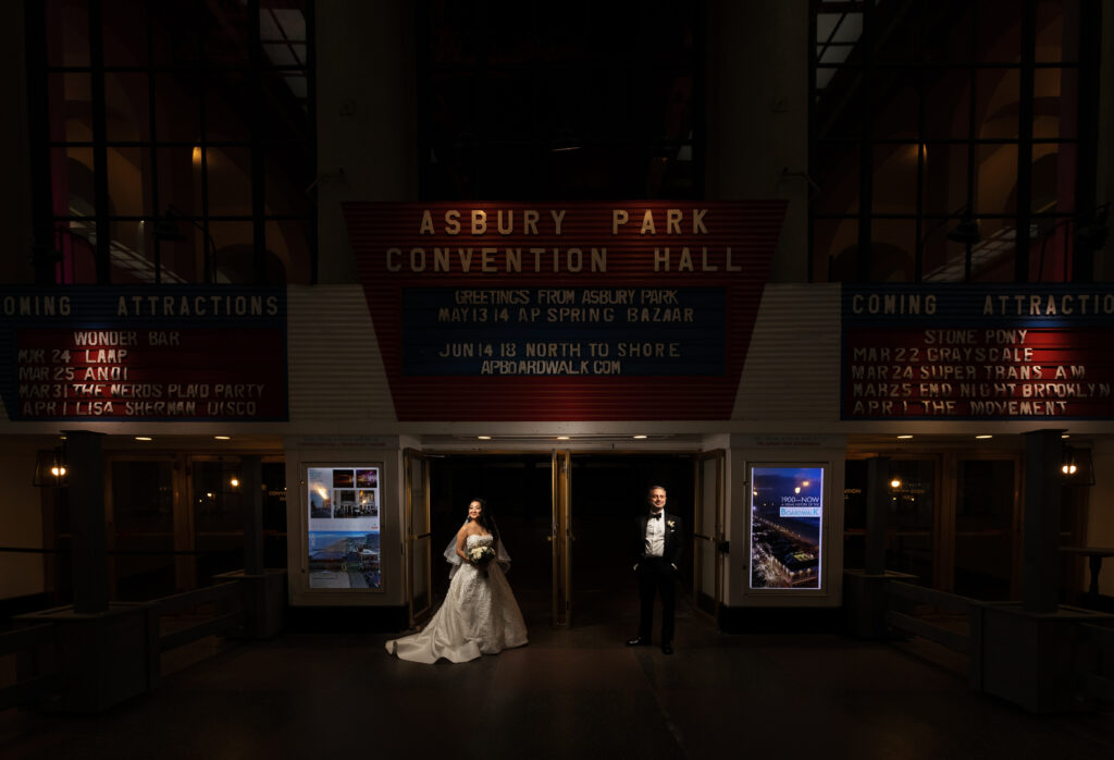 A bride and groom captured by New Jersey Wedding Photographer Jarot Bocanegra, standing in front of the Austin Park Convention Hall.