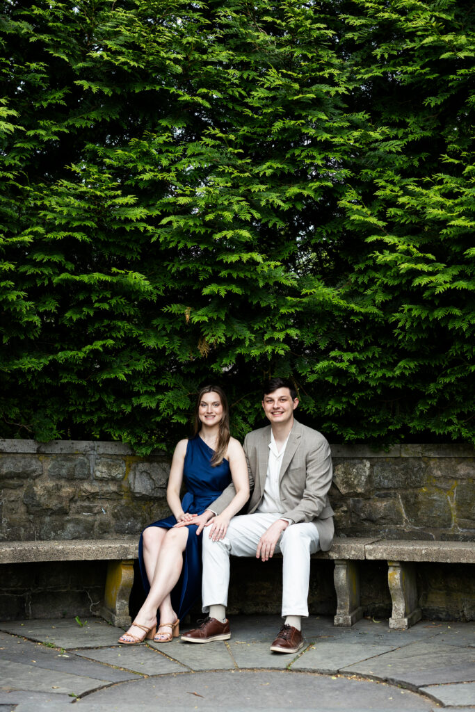 A couple sitting on a stone bench at the New Jersey Botanical Garden during their engagement session, captured by New Jersey Wedding Photographer Jarot Bocanegra.