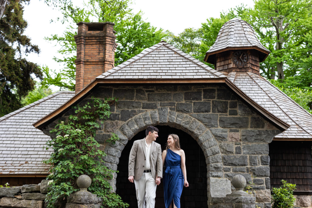 A couple during their engagement session walking in front of a stone house at New Jersey Botanical Garden, captured by New Jersey Wedding Photographer Jarot Bocanegra.