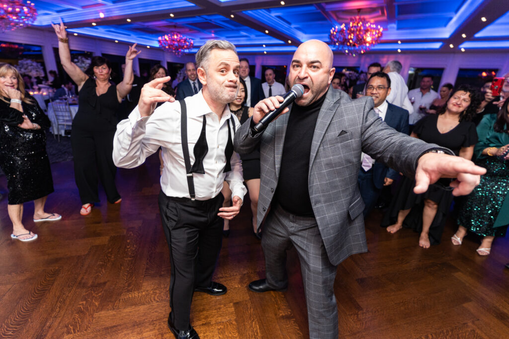 Two men singing at a wedding reception at The Mill Lakeside Manor, captured by New Jersey Wedding Photographer Jarot Bocanegra.