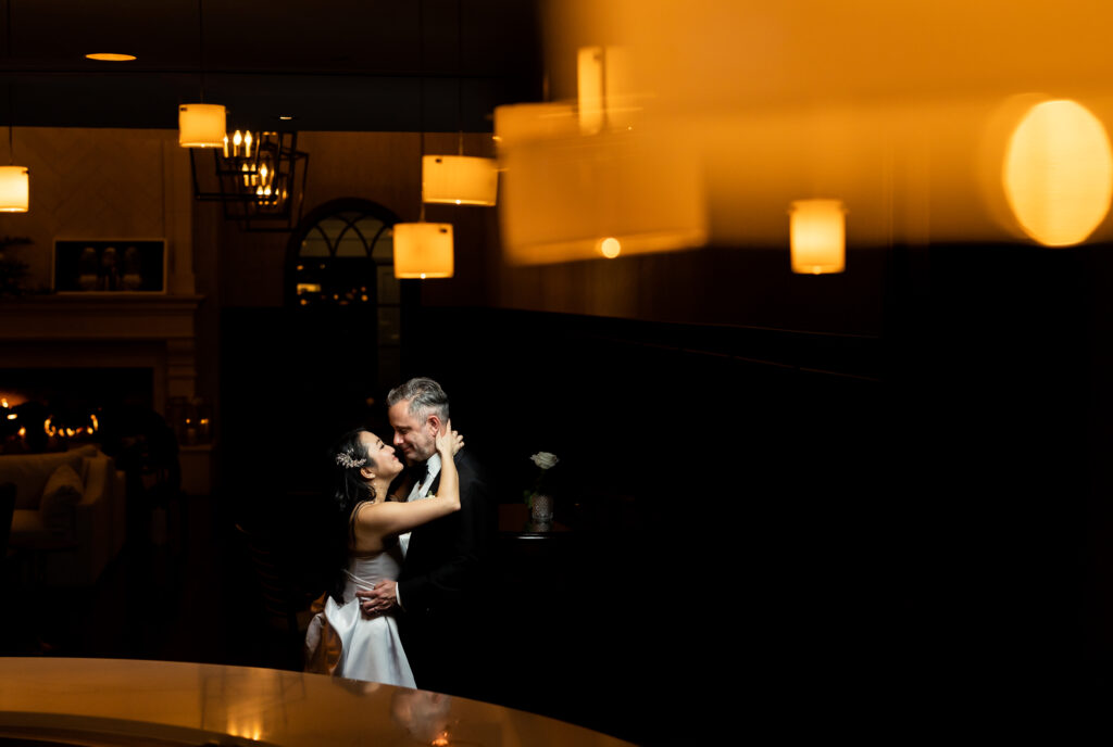 A bride and groom embracing in the library of The Mill Lakeside Manor, captured by New Jersey Wedding Photographer Jarot Bocanegra.