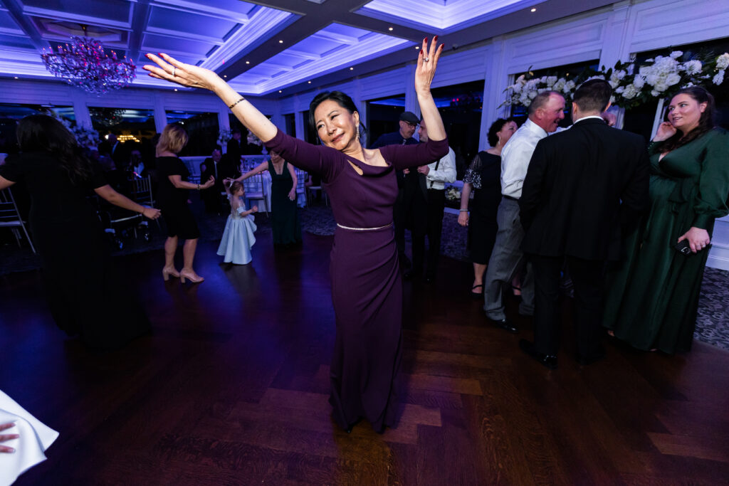 A woman in a purple dress dancing at a wedding reception, captured by New Jersey Wedding Photographer Jarot Bocanegra.
