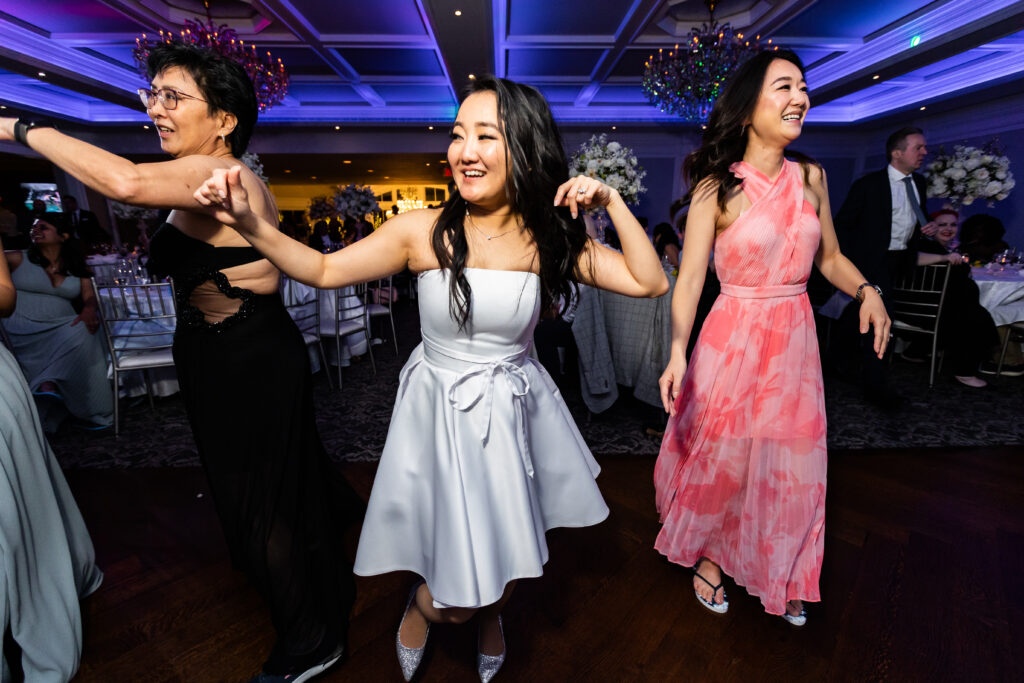 A group of women dancing at a wedding reception, captured by New Jersey Wedding Photographer Jarot Bocanegra.
