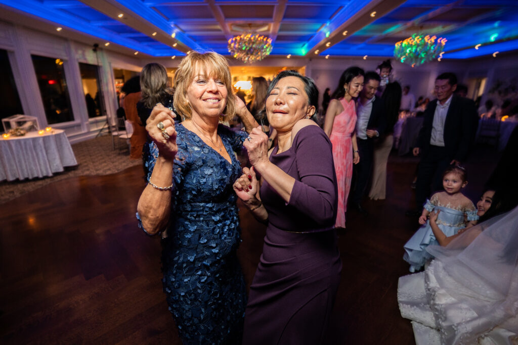 Two women dancing at a wedding reception, captured by New Jersey Wedding Photographer Jarot Bocanegra.
