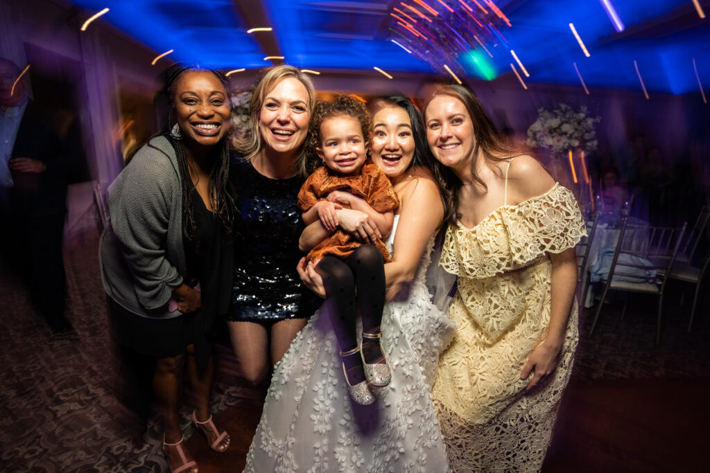 A bride and her bridesmaids, captured by New Jersey Wedding Photographer Jarot Bocanegra, pose for a photo at a wedding reception.