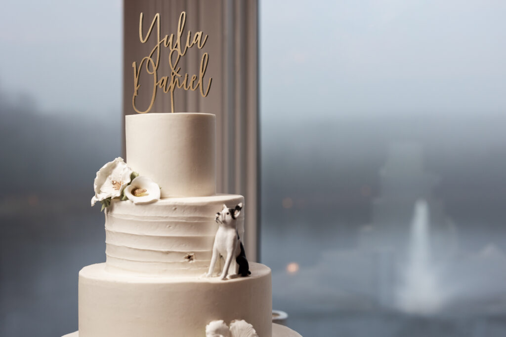 A wedding cake captured by New Jersey Wedding Photographer Jarot Bocanegra sits on top of a table in front of a window.
