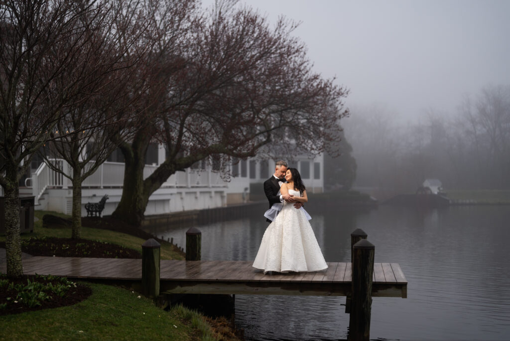 A bride and groom, captured by New Jersey Wedding Photographer Jarot Bocanegra, standing on a dock in the fog.